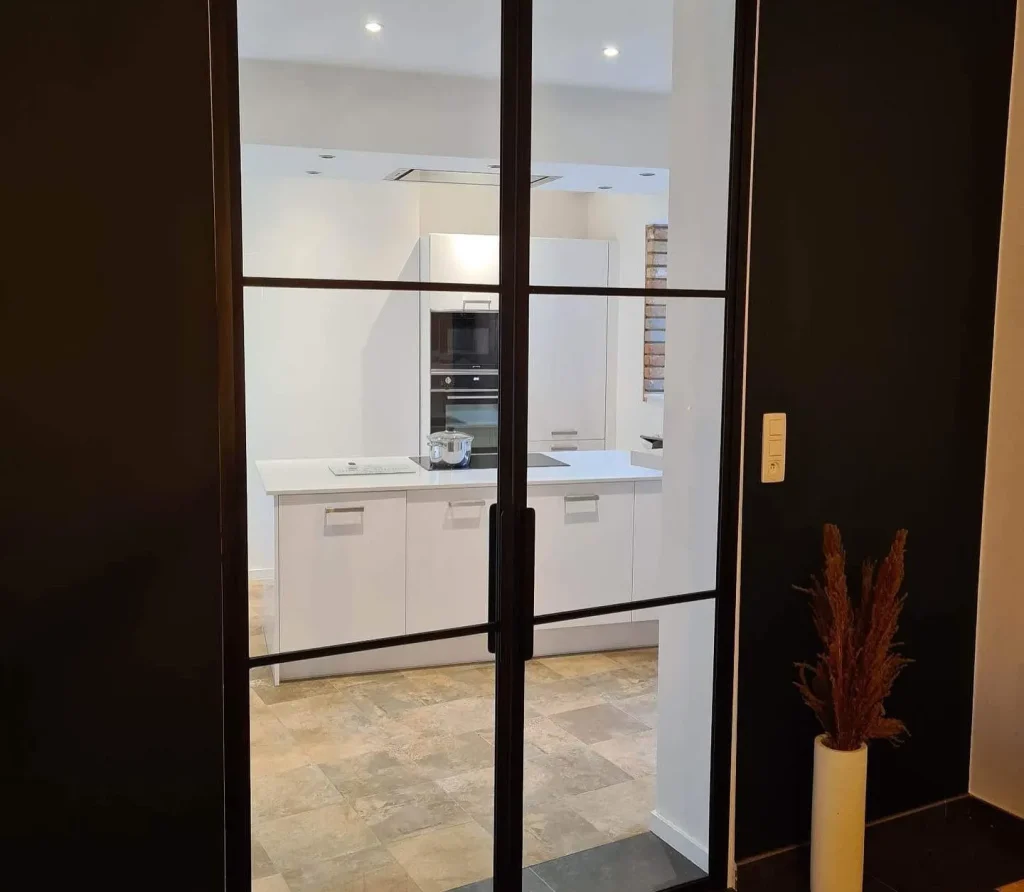 Double porte verrière battante type atelier à croisillons noir, réalisation Metal Hanart en accès de cuisine