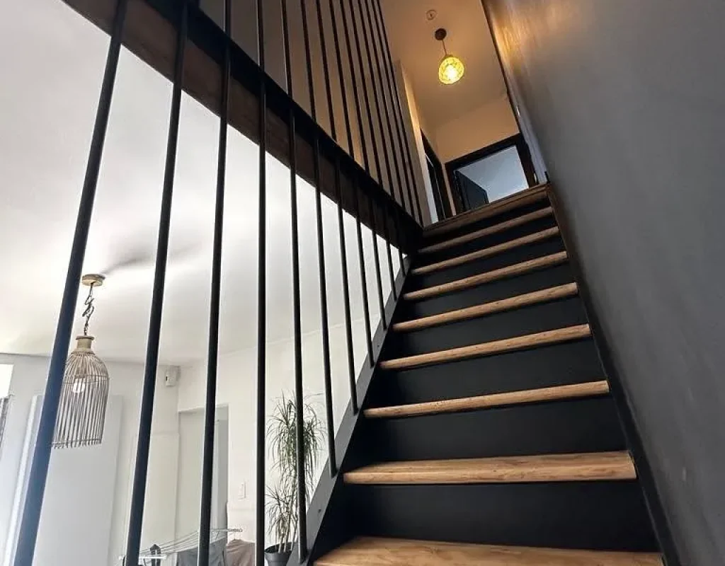 Escalier avec marches en bois massif et garde-corps à barreaudage métallique noir, réalisation Metal Hanart