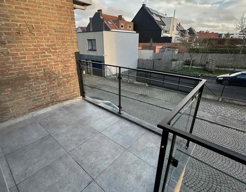 Garde-corps en verre et acier noir sur terrasse en toiture, réalisation Metalhanart avec vue dégagée sur le quartier