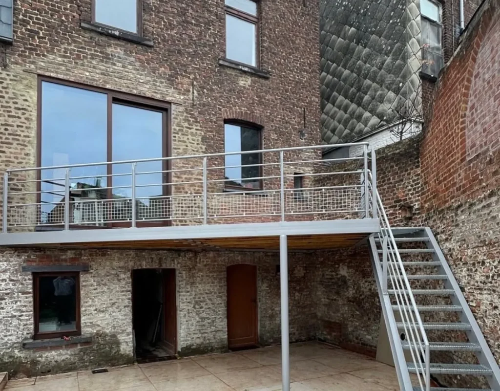 asserelle métallique extérieure avec escalier en acier galvanisé, réalisation Metalhanart en façade arrière de maison en briques