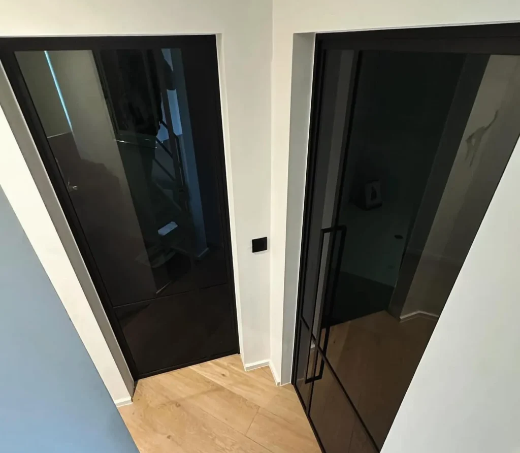 Portes vitrées type atelier avec vitrage teinté noir en aluminium, réalisation Metal Hanart dans un couloir à l'étage
